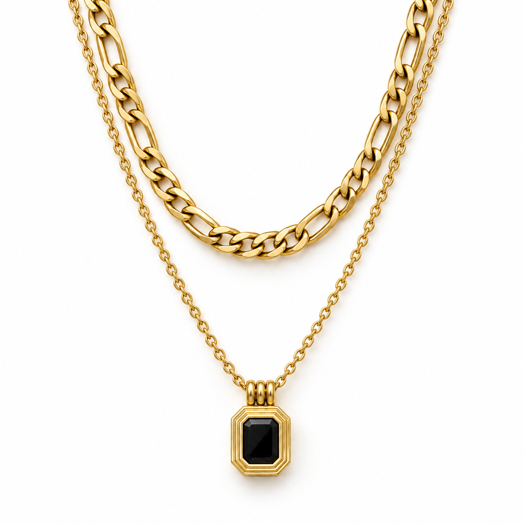 Layered necklace with black pendant styled on a pale stone surface