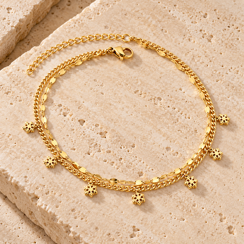 Gold-tone snowflake charm anklet on white background