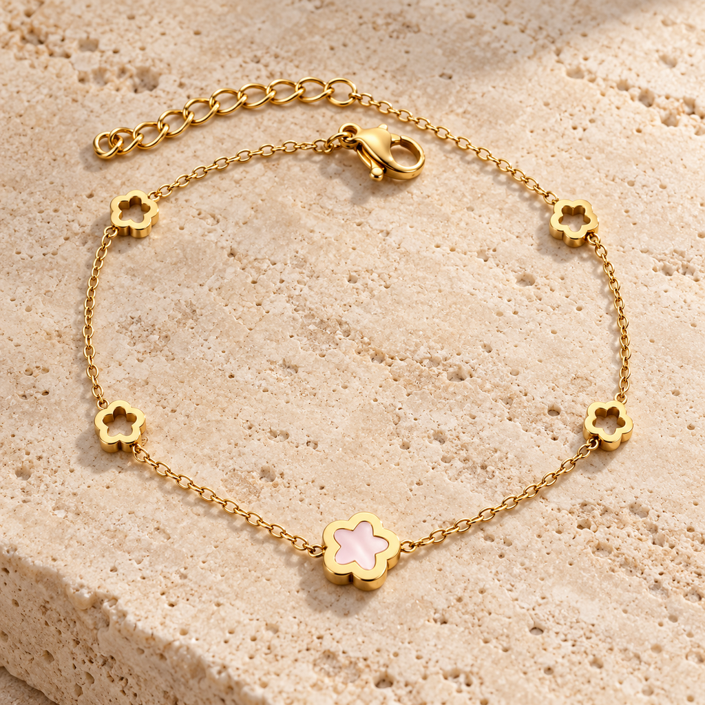 Gold-tone floral station bracelet with pale pink centre worn on wrist