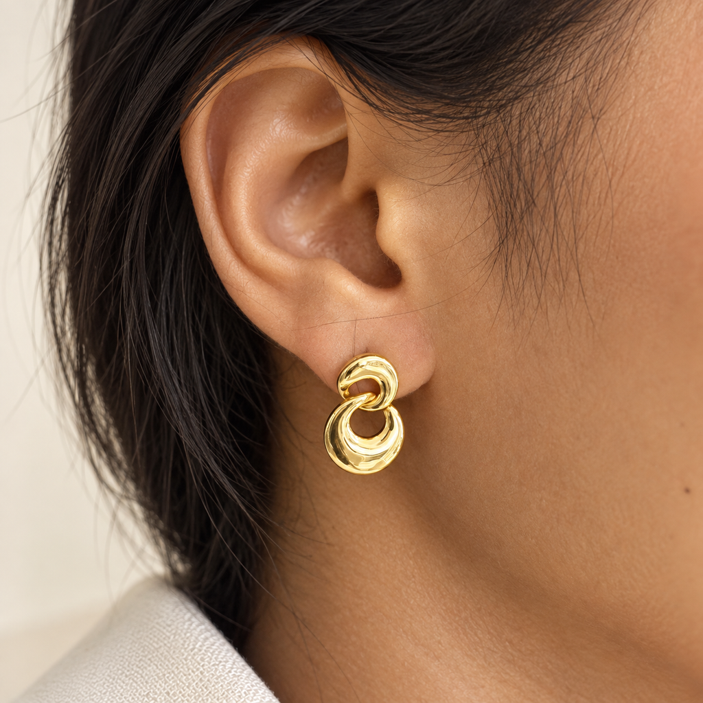 Gold-tone double-link earring worn on ear