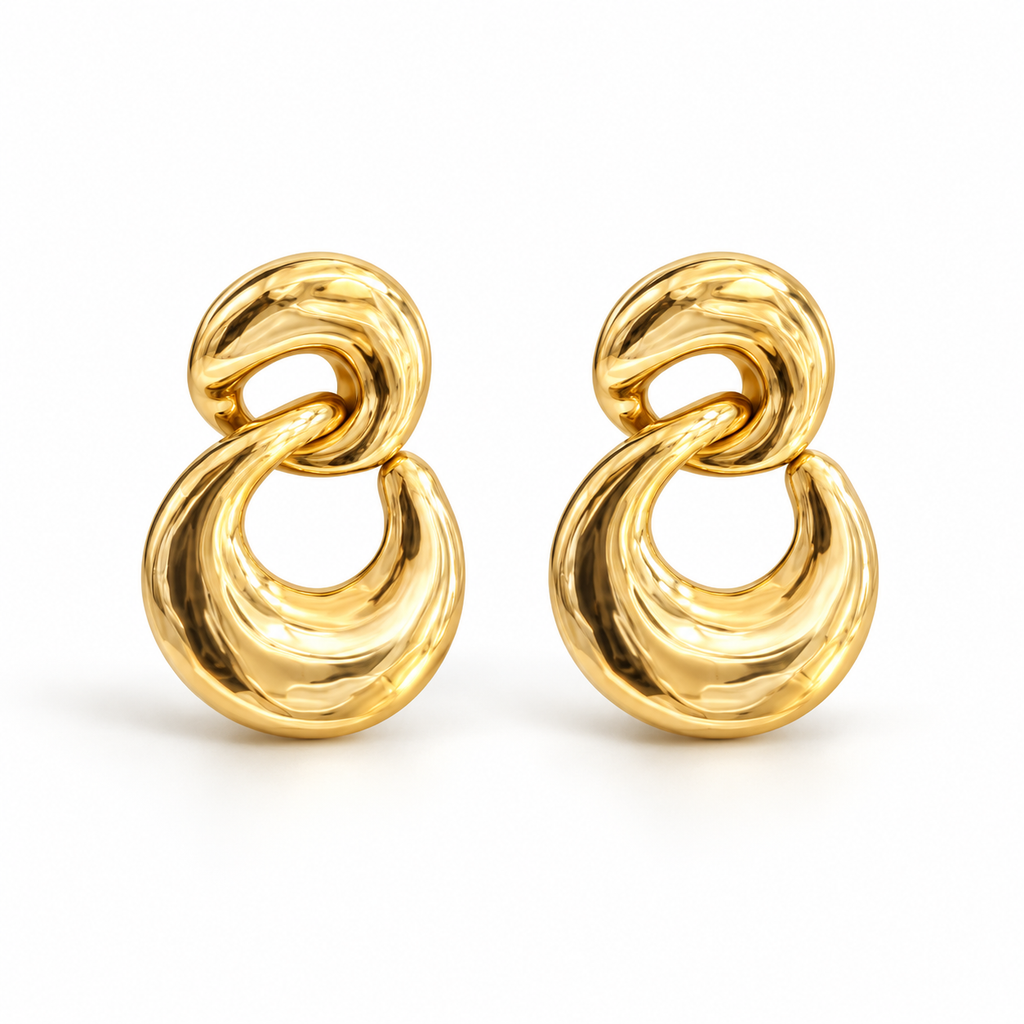 Pair of sculpted gold-tone double-link earrings displayed on stone